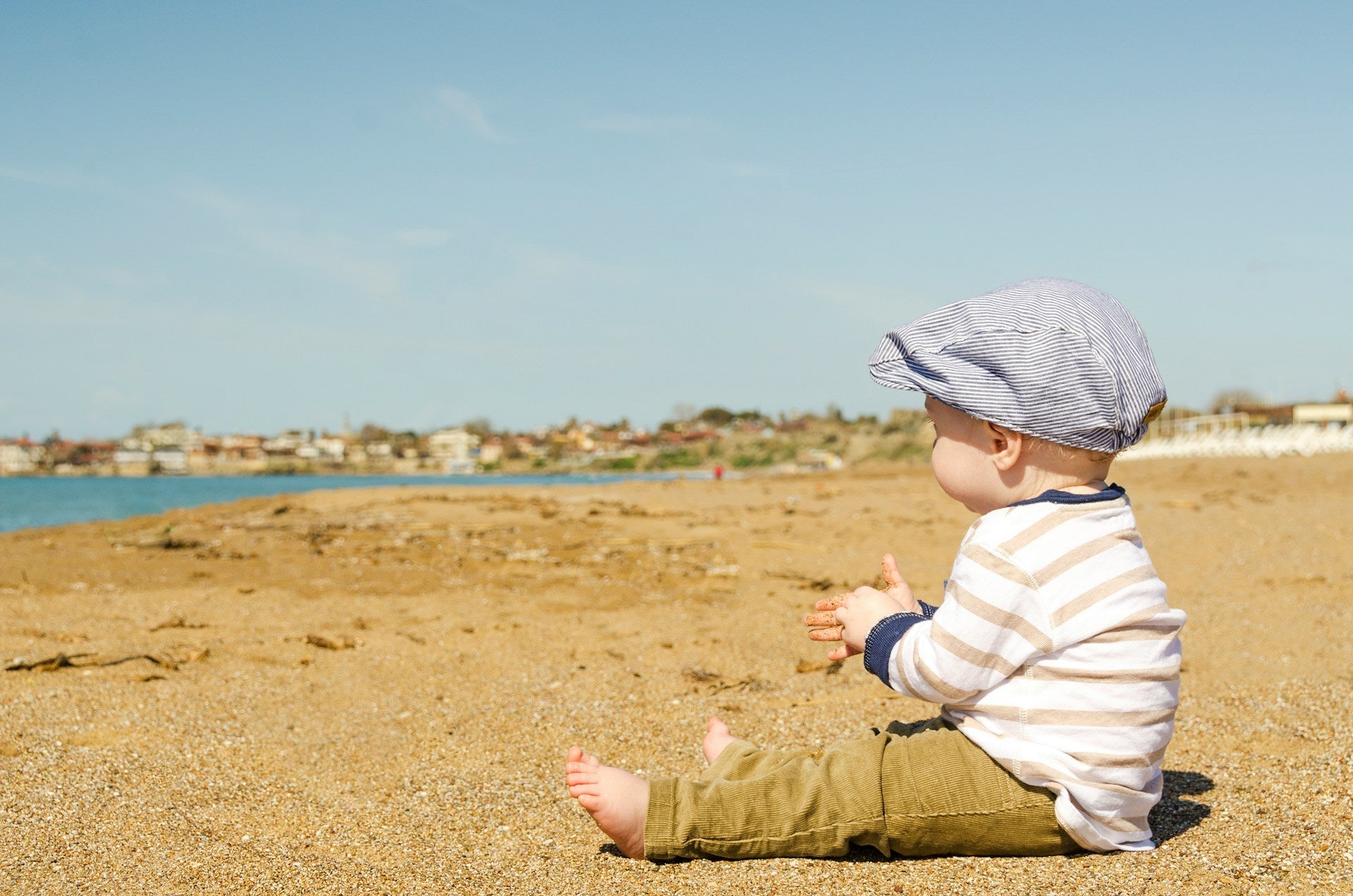 A contented baby outdoors on a beach